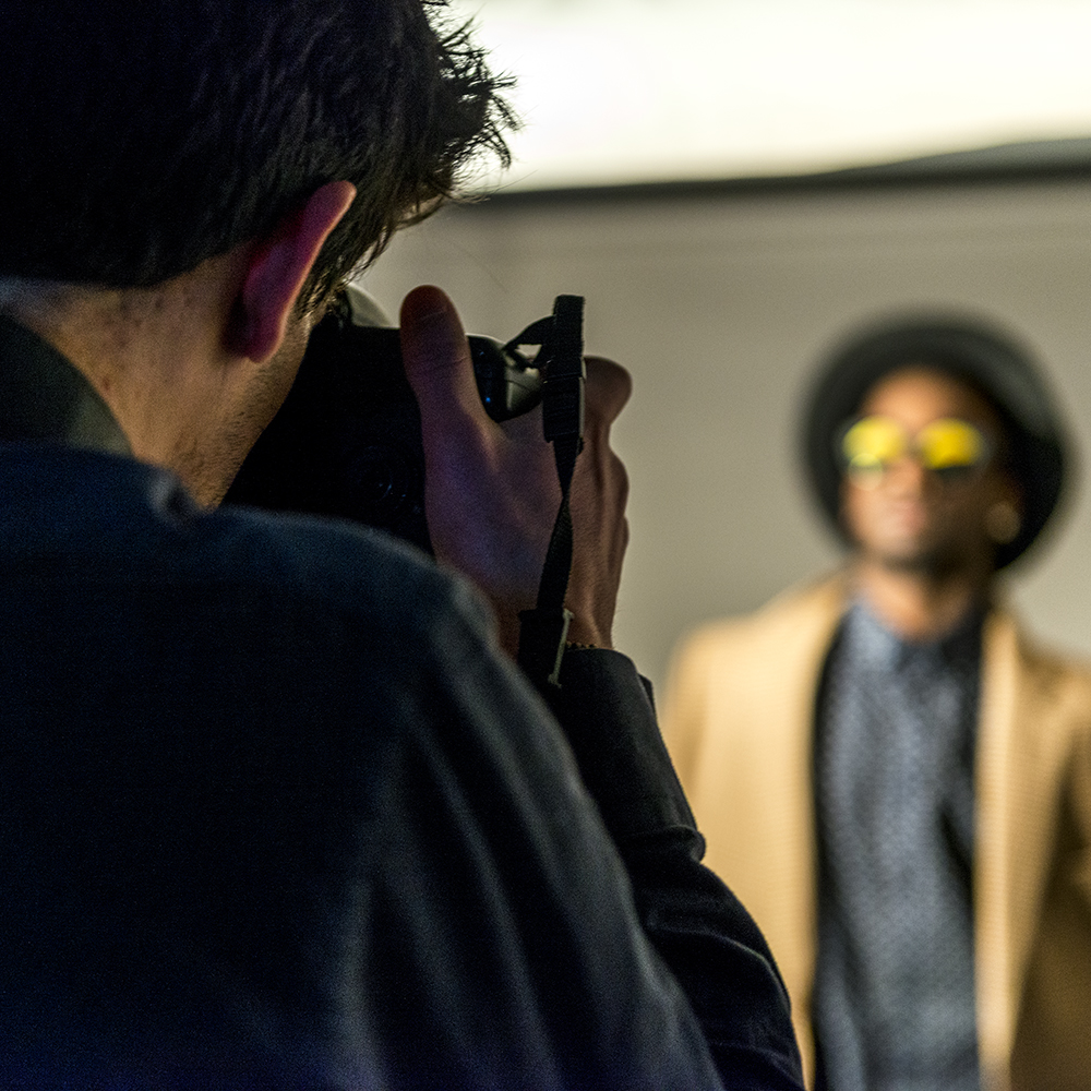 Un homme photographie un modèle portant des lunettes de soleil dans les studios phot de l'ETPA. 