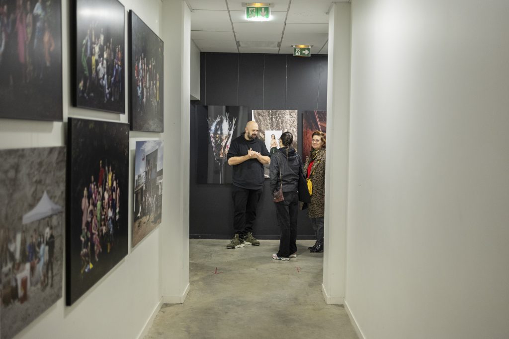 Exposition photos des étudiants de l'ETPA avec des personnes qui discutent des photographies présentées.