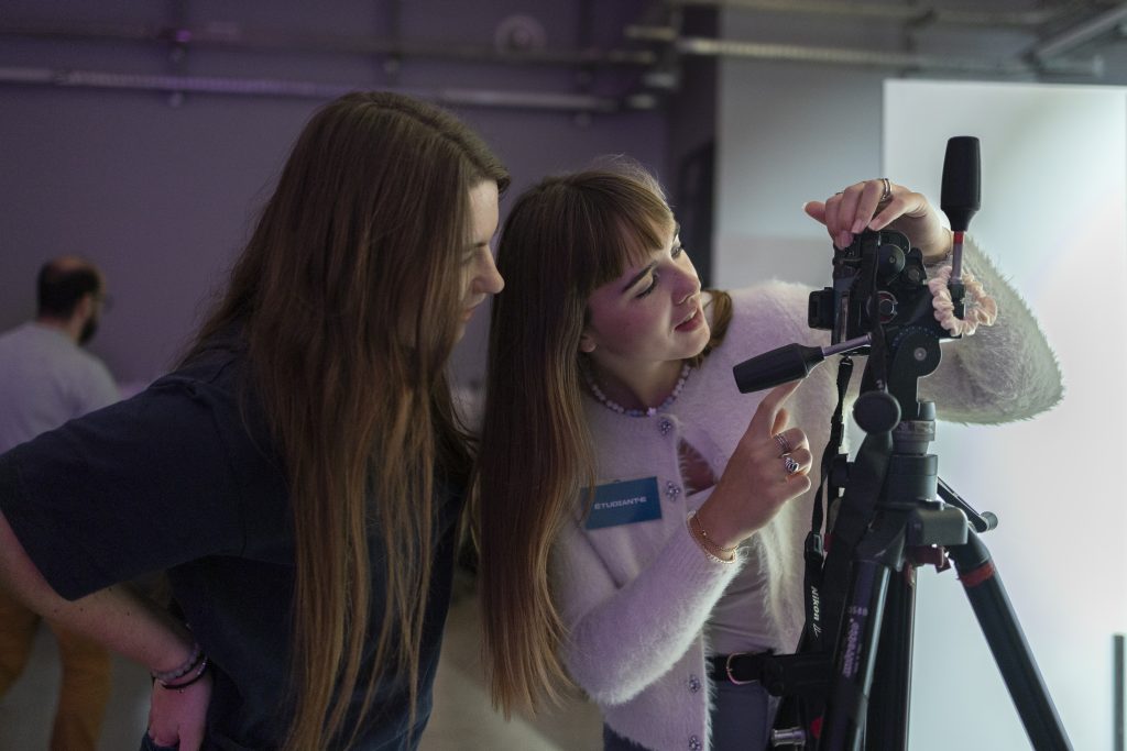 Des étudiantes règlent un objectif pour concentrées sur l'appareil photo. 