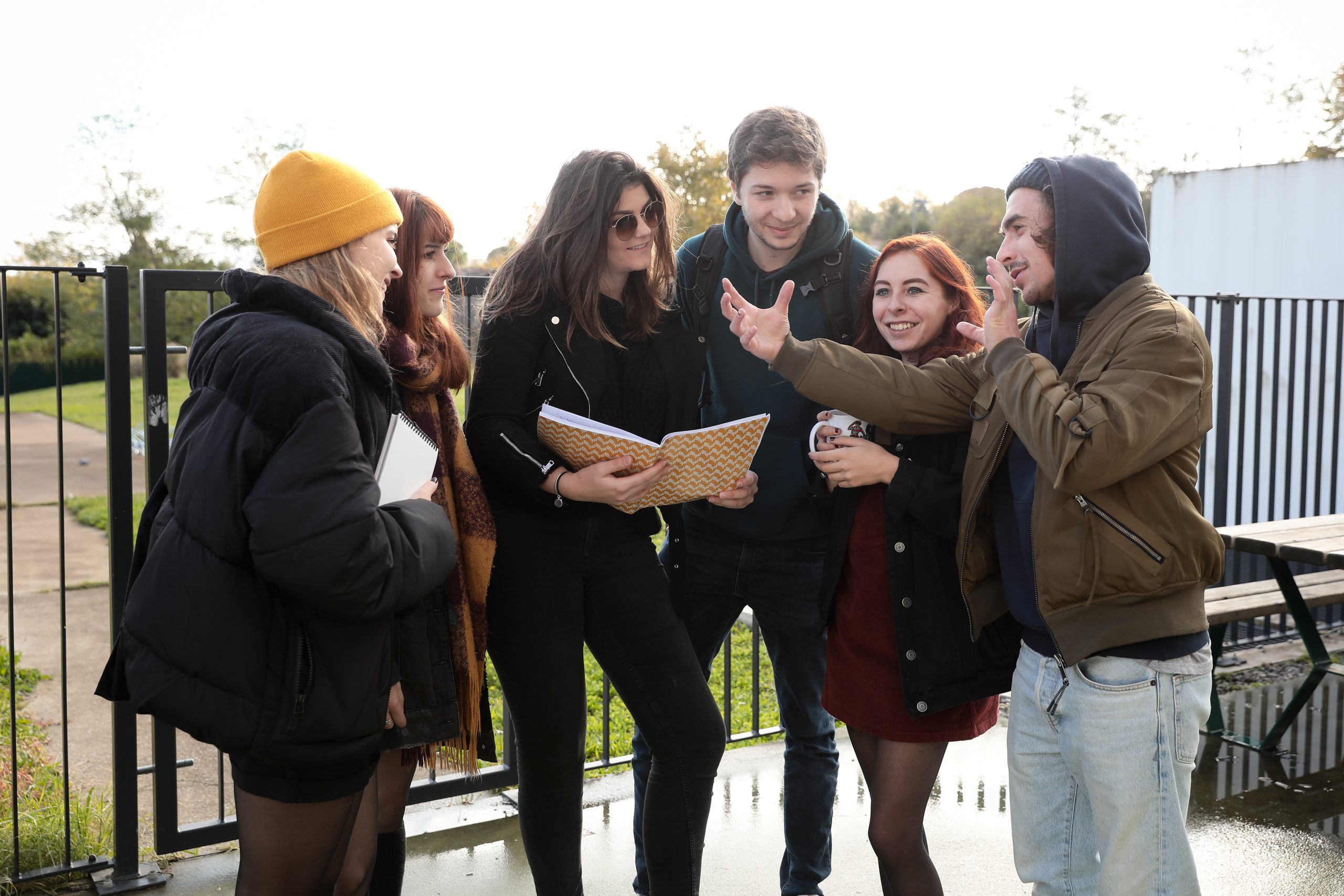 Des étudiants discutent des cahiers à la main en extérieur du campus ETPA Toulouse.