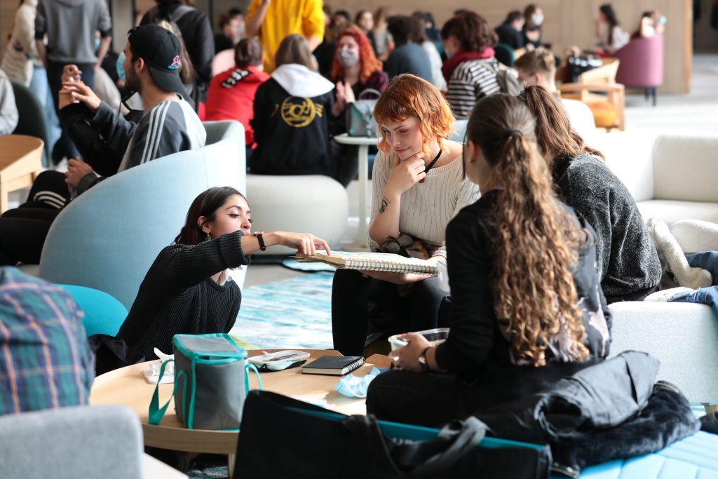 Des étudiantes discutent dans le hall du campus