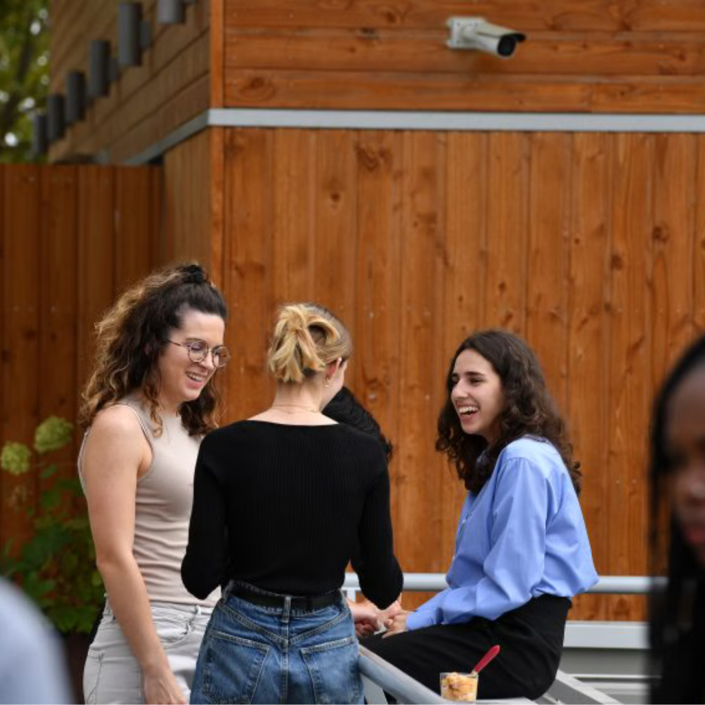 Des étudiantes discutent sur le campus.