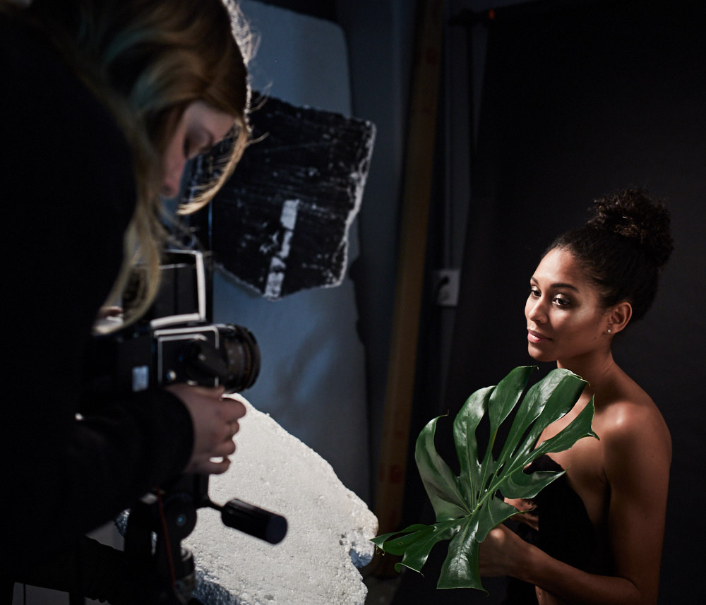 Une jeune femme prend la pose avec une grande feuille dans les studios de l'ETPA.