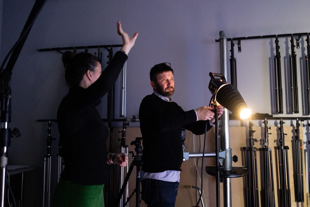 Un professeur et une élève discutent de la lumière lors d'une séance photo dans les studios de l'ETPA.