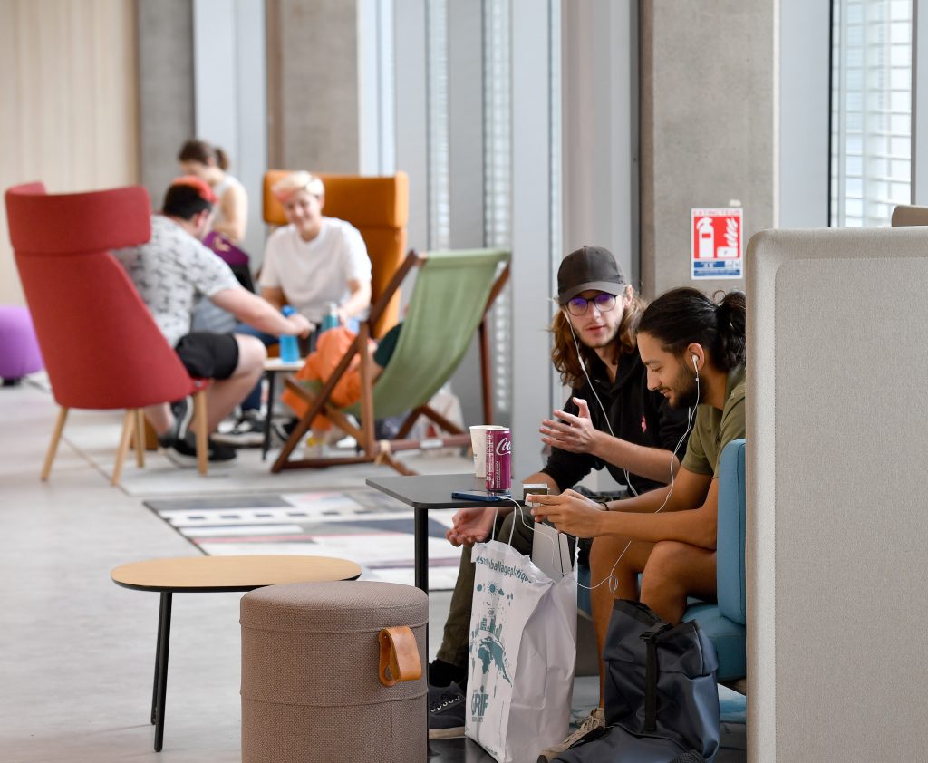 Des étudiants discutent dans des espaces dédiés et colorés du campus.